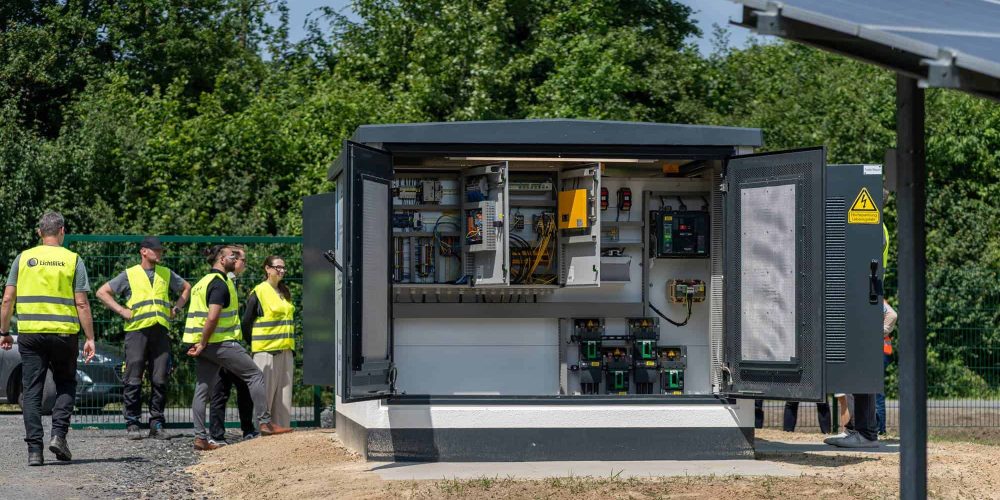 Kompakt-Trafostation im Aufbau vor Landschaftskulisse im Münsterland. Kompakt-Trafostation von Faber E-Tec im Einsatz beim Solarprojekt in Ennigerloh