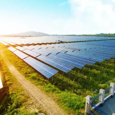 Großer Solarpark auf Freifläche bei Sonnenaufgang mit Kompaktstation und Kompakt Trafostation zur umweltfreundlichen Energieerzeugung
