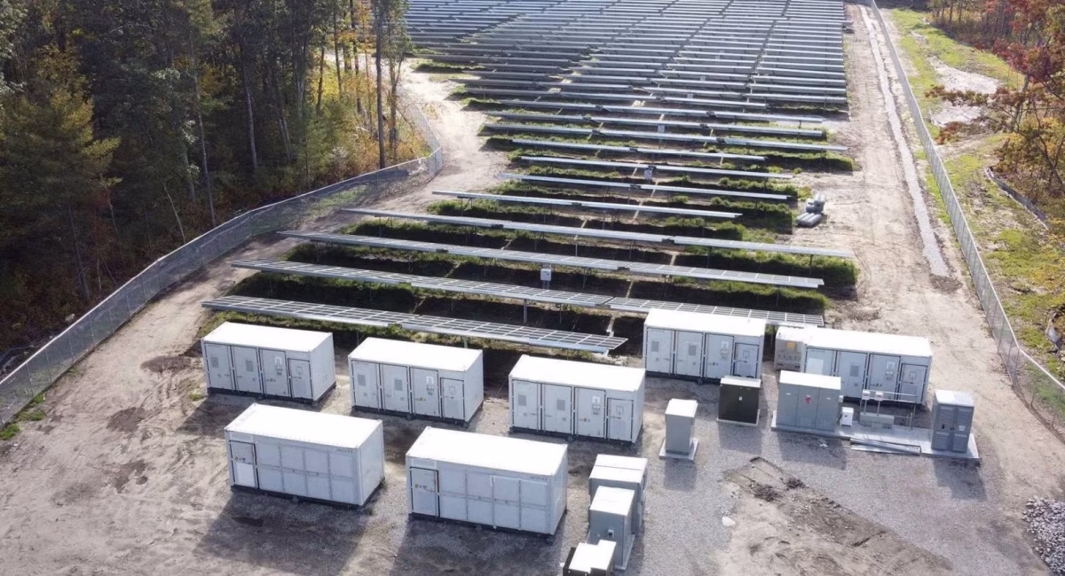 Moderne Batteriespeicher-Lösung (BESS) von Faber E-Tec neben einer Schnellladestation, um Lastspitzen im Gewerbe abzufangen.